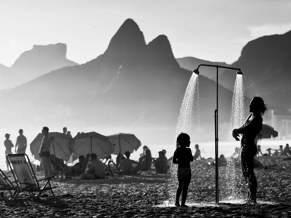  巴西里约热内卢的沙滩上冲凉的母子。来自摄影师Giovani Garcia。 
