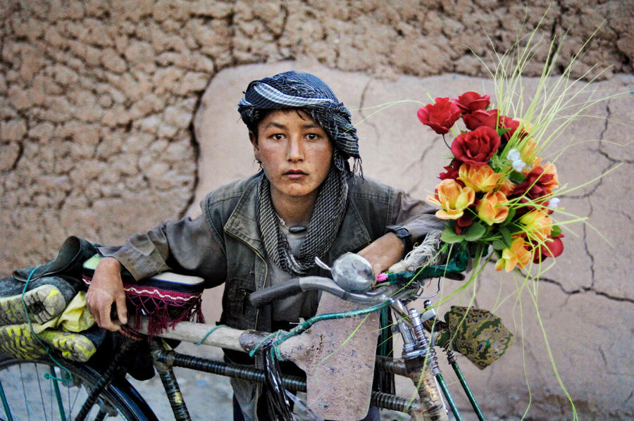  从工地上骑自行车回来的孩子，Steve McCurry摄于阿富汗喀布尔。 