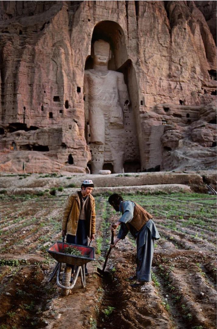  在阿富汗巴米扬大佛雕塑前开垦种植农作物的人，Steve McCurry摄于1992年。在2001年这些佛像雕塑被塔利班摧毁。 