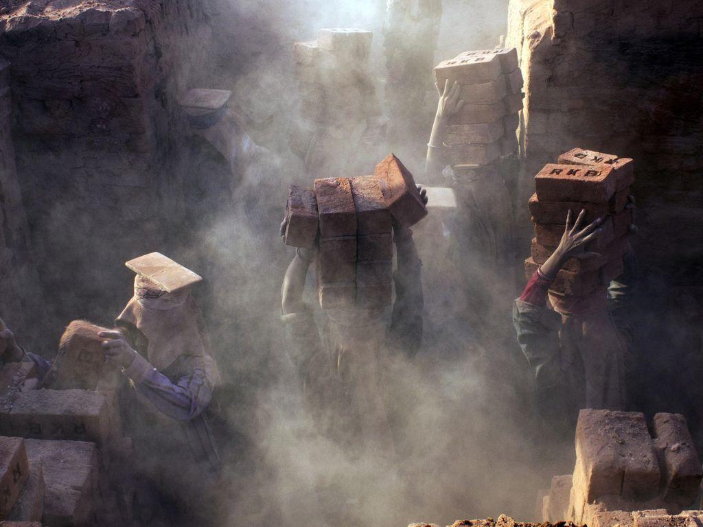  在灰尘中砖厂的女工人，她们每天拿着微薄的薪水，工作18个小时，TEJAL MEWAR摄于印度。 
