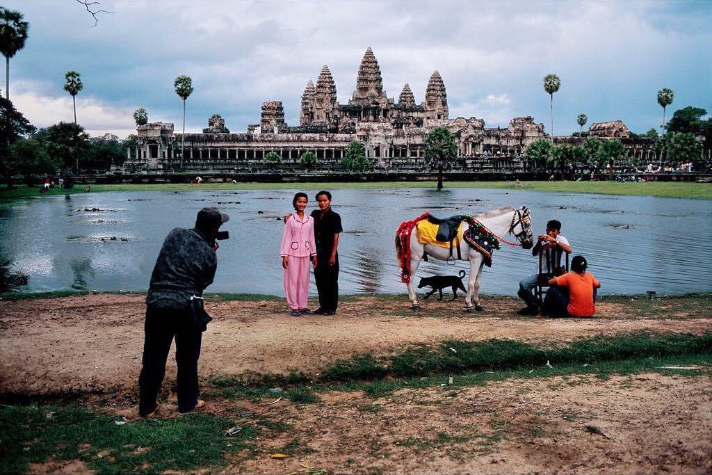  在吴哥窟前为游客拍照的摄影师，Steve McCurry摄于1999年柬埔寨。 
