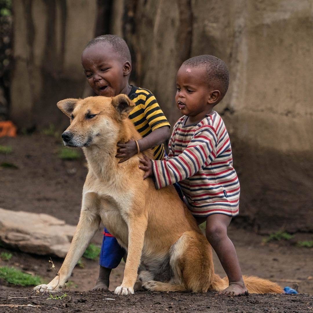  与狗狗一起玩耍的孩子，Cristina Mittermeier摄于肯尼亚马赛马拉。 