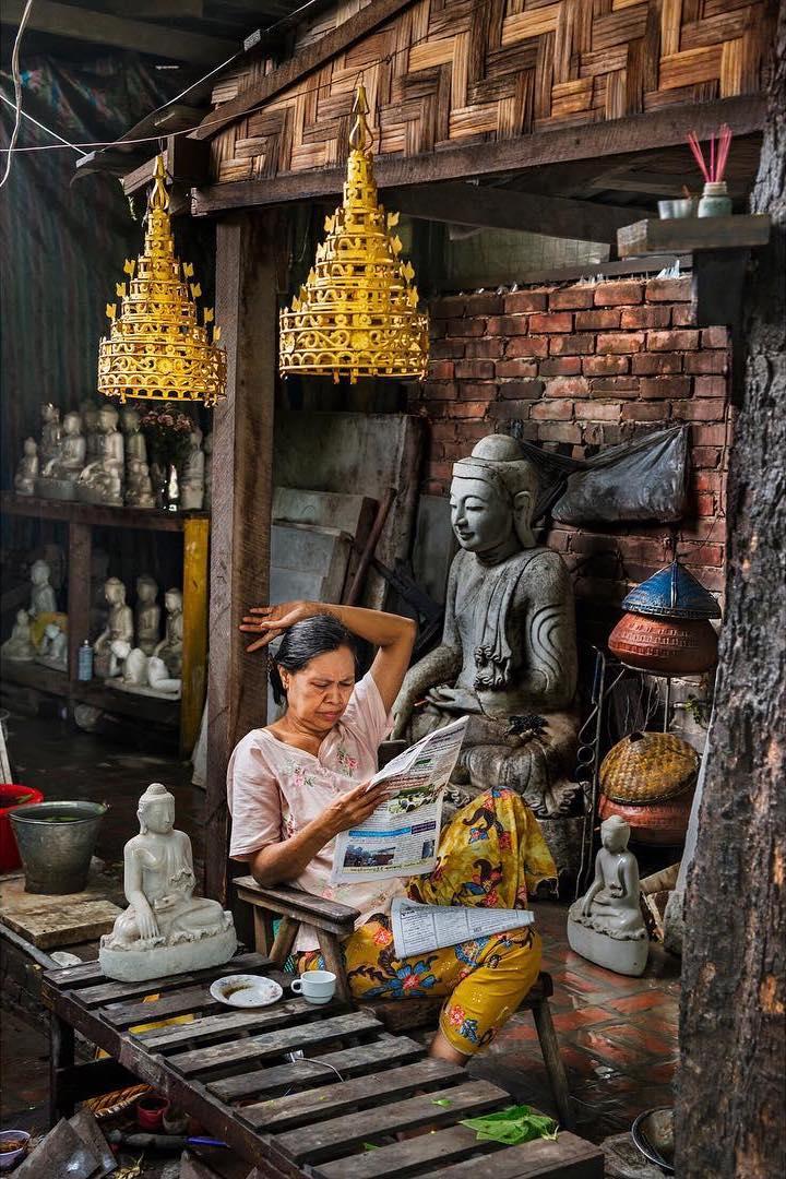  卖佛像的小店店主，Steve McCurry摄于2013年缅甸曼德勒。 