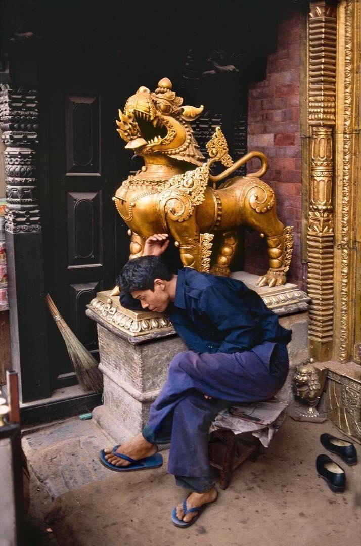  在雕塑前睡着的人，Steve McCurry摄于2004年尼泊尔加德满都。 