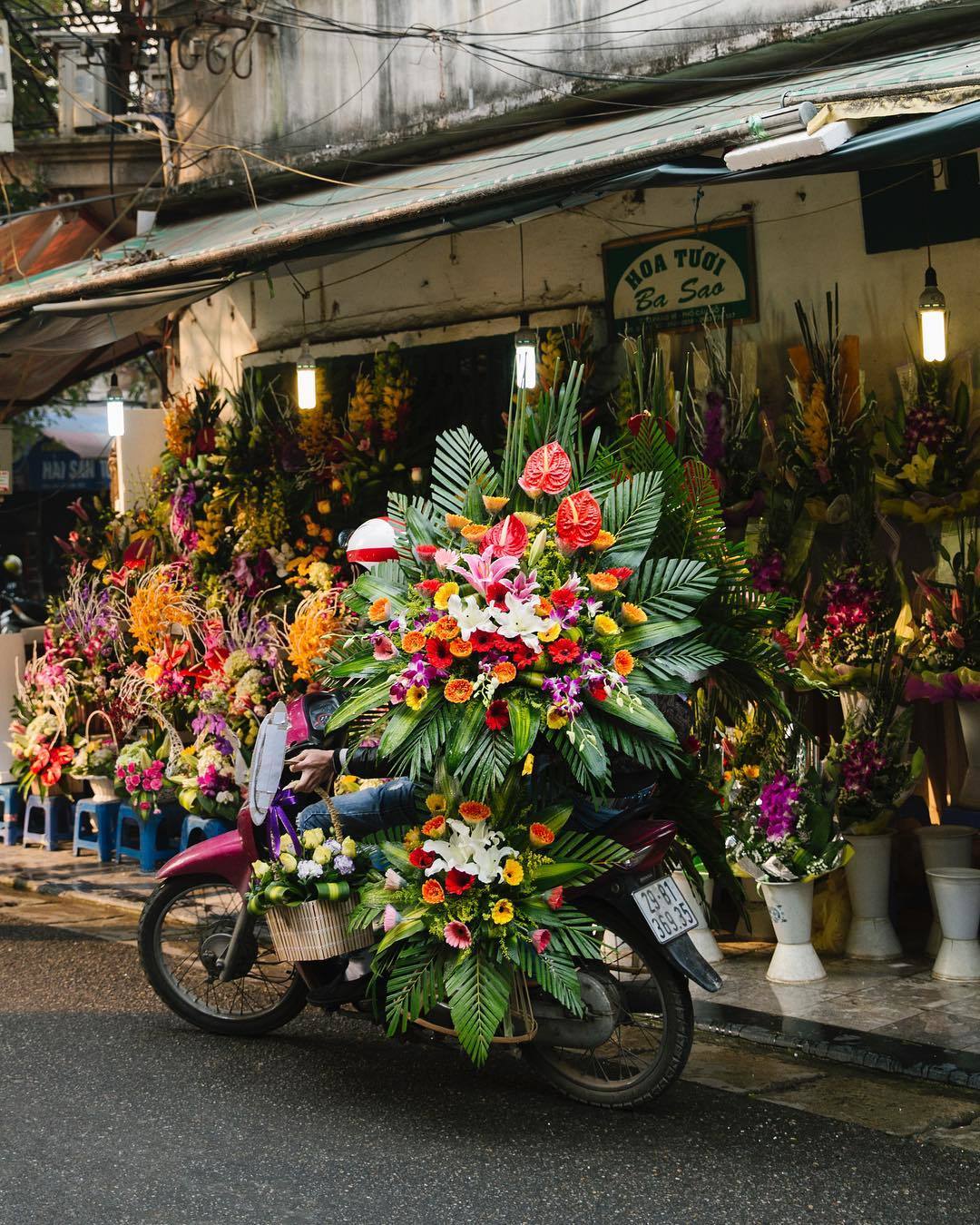  越南河内骑着摩托车卖花的人，来自摄影师Jessica Sample。 