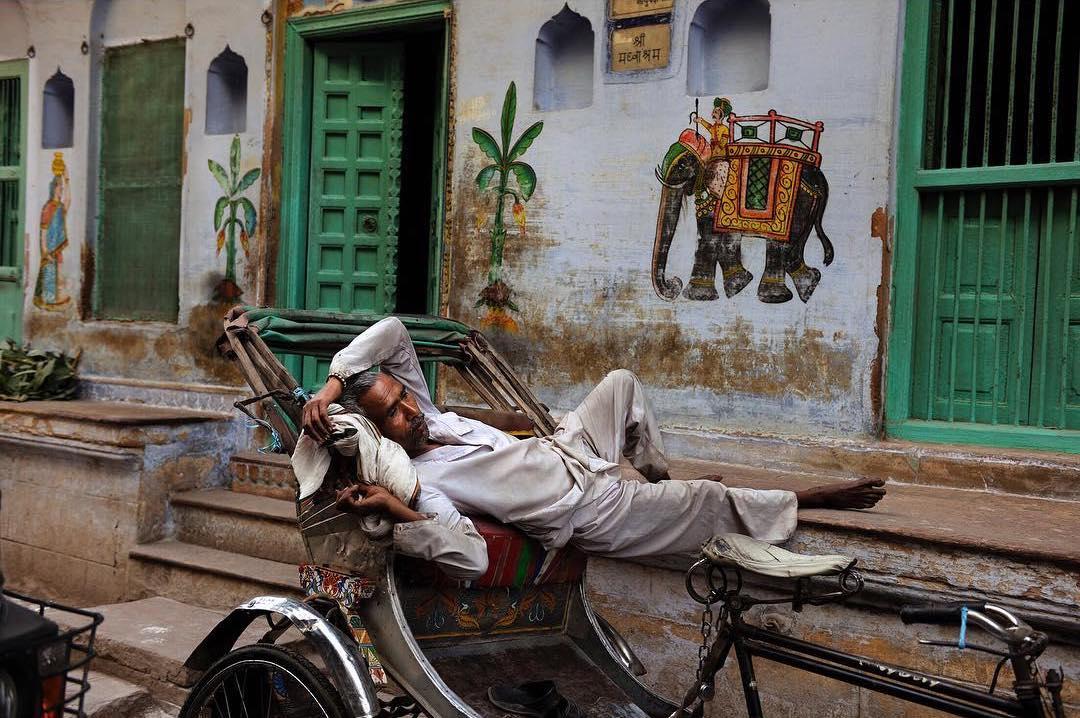  在人力车上休息的车夫，Steve McCurry摄于2010年印度瓦拉纳西。 