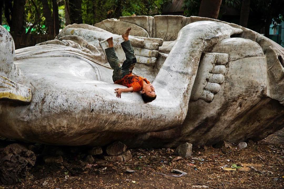  在倾倒的佛像上玩耍的孩子，Steve McCurry摄于2013年缅甸曼德勒。 