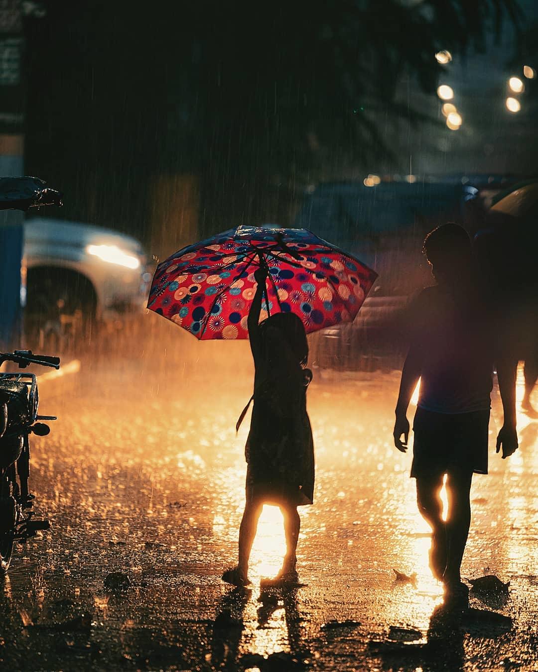  雨天街头撑伞的孩子，Jilson Tiu摄于菲律宾马尼拉。 