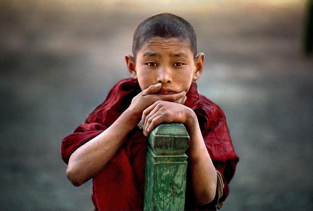  靠在栏杆上的小和尚，Steve McCurry摄于1978年印度。 