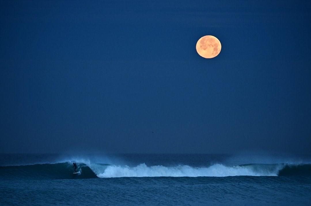 满月下的冲浪者，来自摄影师Donald Miralle。 