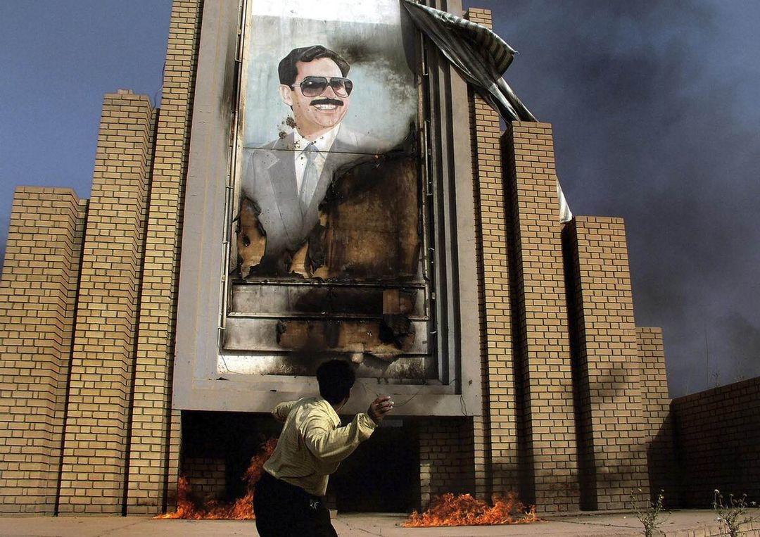  向萨达姆画像投掷石块的人，Alex Majoli摄于2003年4月伊拉克首都巴格达。2003年3月20日美军发动伊拉克战争。 