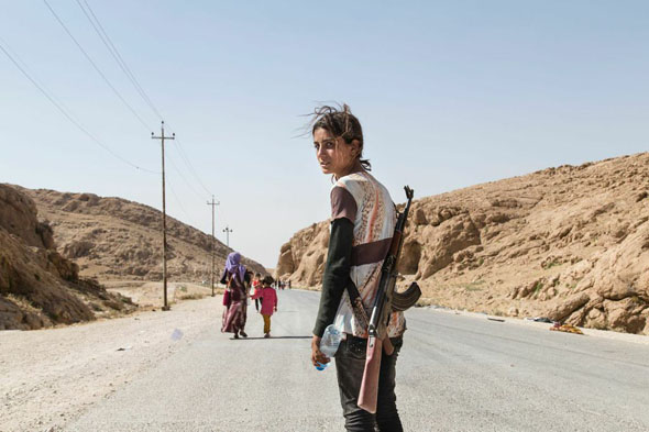 地球故事：战争，摄影师： Zmnako Ismael。伊拉克，十四岁的少女Runak Bapir Gherib，持枪保护自己的家人。